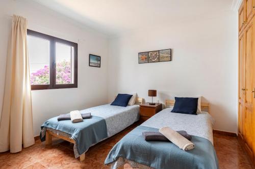 a bedroom with two beds and a window at Villa Car&Melo in Nazaret