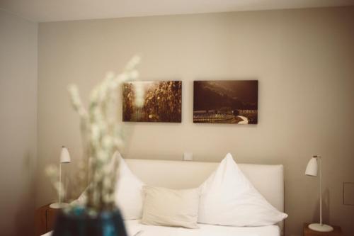 a bedroom with a bed with three paintings on the wall at Landers Ferienwohnung in Sankt Martin