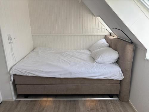 a small bed in a small room with aigunigunigun at Waterzicht 3 in Uitwellingerga