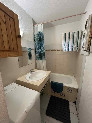 une petite salle de bain avec un lavabo et une baignoire dans l'établissement Pavillon Duplex T2/terrasse, au Cap d'Agde