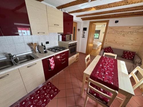 a kitchen with a table and a kitchen with a dining room at Rifugio di Niki e Kristine in Falcade