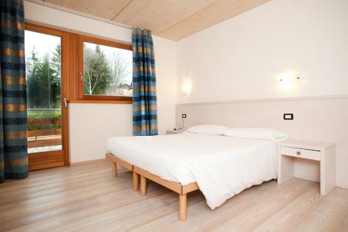 sypialnia z dużym łóżkiem i oknem w obiekcie Bio Hotel Benny w mieście Commezzadura