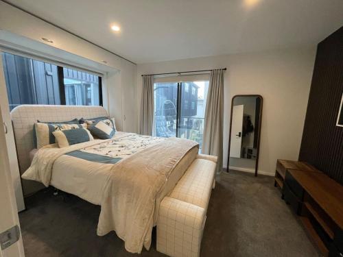 a bedroom with a large bed and a large window at Cosy and Central Family Home in Christchurch