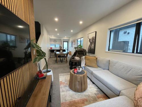 a living room with a couch and a table at Cosy and Central Family Home in Christchurch