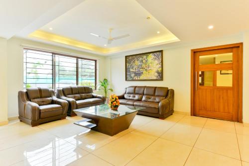 a living room with two couches and a coffee table at Super Townhouse Vembanad Tourist Home in Cochin