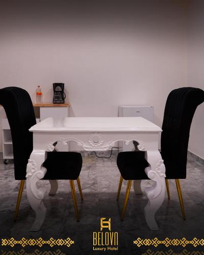a white table with two black chairs in a room at Belova Luxury Hotel, San Cristobal de las Casas in San Cristóbal de Las Casas