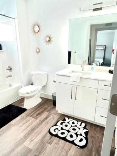 a white bathroom with a sink toilet and a mirror at Beehive Escape -Salt Lake City in Salt Lake City