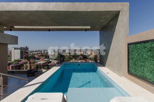 a swimming pool on the roof of a building at Modern Apartment 700m From Shopping Mcal Lopez in Asuncion