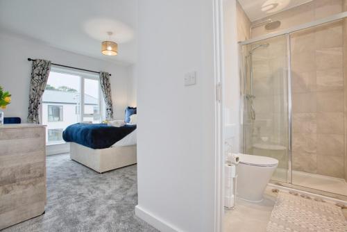 海尔Harveys Yard by Signature Stays - Hayle House - Parking - Sleeps 6的带淋浴的浴室和带床的卧室