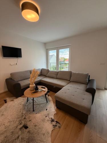 a living room with a couch and a table at Dream Premium Apartman in Mosonmagyaróvár