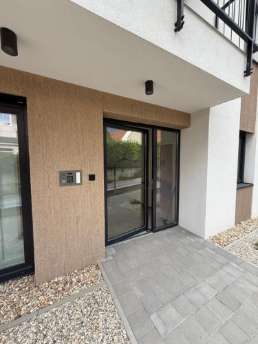 a building with sliding glass doors on it at Dream Premium Apartman in Mosonmagyaróvár