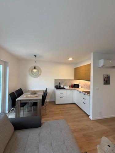 a living room with a table and a kitchen at Dream Premium Apartman in Mosonmagyaróvár