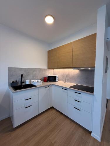a kitchen with white cabinets and a sink at Dream Premium Apartman in Mosonmagyaróvár