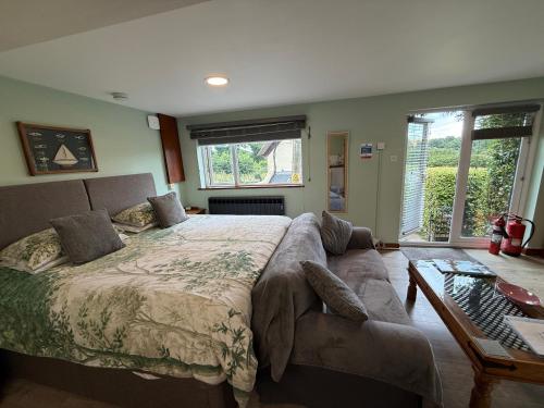 a bedroom with a large bed and a couch at The Studio with Hot Tub in East Budleigh in beautiful countryside in East Budleigh