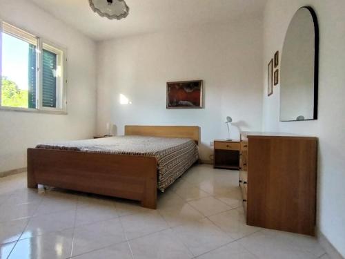 a bedroom with a bed and a dresser and a mirror at Villette Mar Ionio in Nardò
