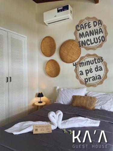 a bedroom with a bed with baskets on the wall at Ka'a Guest House in Ubatuba