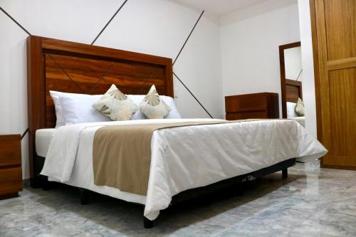 a bedroom with a large bed with white sheets and pillows at Belova Luxury Hotel, San Cristobal de las Casas in San Cristóbal de Las Casas