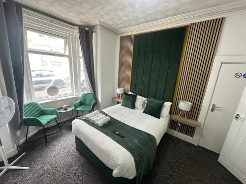 een slaapkamer met een groot bed met een groen hoofdeinde bij ONYX Hotel Blackpool in Blackpool