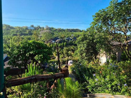 a view of a garden with flowers and trees at An Nhien Serenity in B'su M'rac