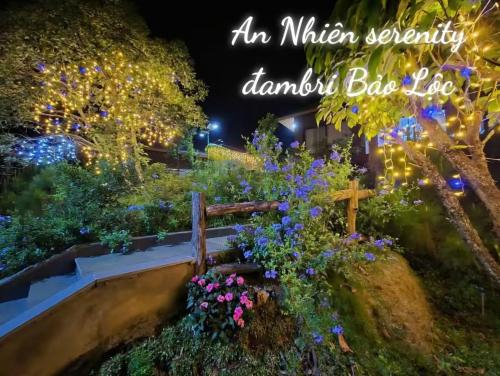 an illuminated garden at night with a wooden bench and flowers at An Nhien Serenity in B'su M'rac