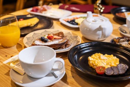 a table topped with plates of breakfast foods and a cup of coffee at Aubrey Hotel Boutique in Santiago