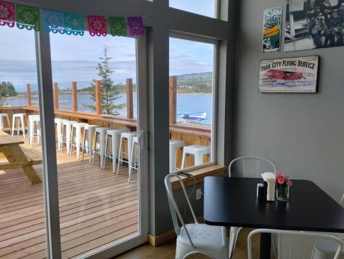 a room with a balcony with a table and chairs at Alderwood Cabin - Homer Seaplane Base in Homer