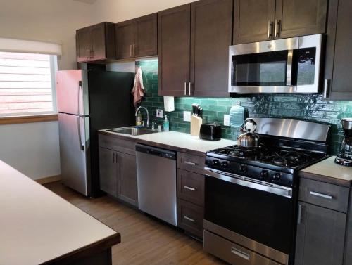 a kitchen with a stove and a refrigerator at Alderwood Cabin - Homer Seaplane Base in Homer