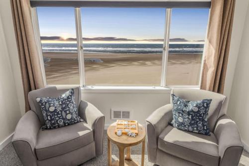 sala de estar con 2 sillas y ventana grande en Oceanfront Suite - Top Floor - Sleeps 4 - Pool and Sauna, en Lincoln City