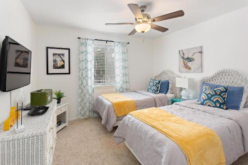 Un dormitorio con dos camas y un ventilador de techo. en Ocean Walk W4, en Mallory Park