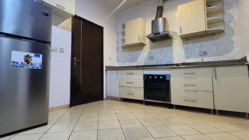 a kitchen with a stainless steel refrigerator and white cabinets at the luxury Apartment in Lekki