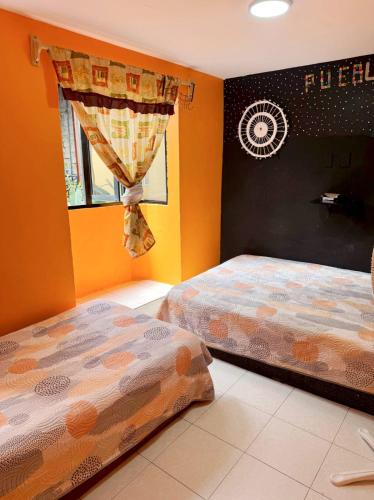 a bedroom with two beds and a window at Alo México in Mexico City