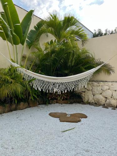 a hammock in a garden with a teddy bear on the ground at Villa Privada con Piscina - Playas del Atlantico in Tubará