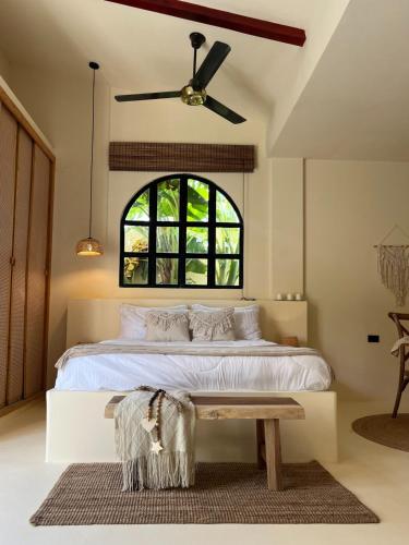 a bedroom with a large white bed with a table at Villa Privada con Piscina - Playas del Atlantico in Tubará