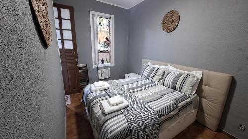 - une chambre avec un lit doté de couvertures et d'oreillers blancs dans l'établissement Casa com amplo quintal, a paz ao lado do Centro, à Rio de Janeiro