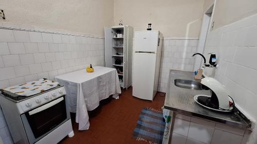 une petite cuisine avec une table et un réfrigérateur dans l'établissement Casa com amplo quintal, a paz ao lado do Centro, à Rio de Janeiro