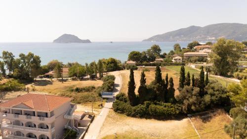 an aerial view of a house with trees and the ocean at Palm Studios, 350m from Agios Sostis Beach, by ZanteWize in Zakynthos Town