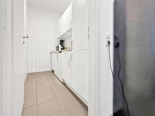 a kitchen with white cabinets and a tile floor at Zentrales Stgt 3SZ 12 Pers in Stuttgart
