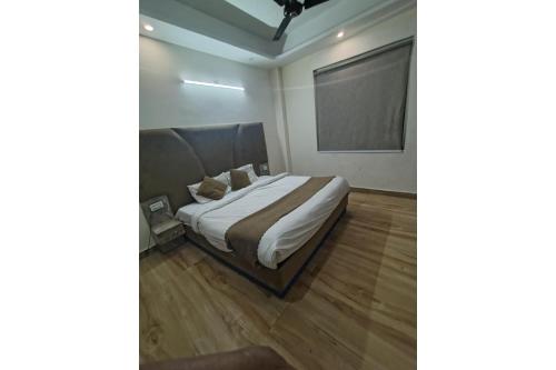 a bedroom with a bed with white sheets at Hotel Urban Eminence Banjara Hills, Near Shri Jagannatha Swami Temple in Hyderabad