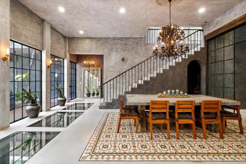 a dining room with a table and chairs and a chandelier at Casa Halo - Mansion, Nightclub, Pool, Sonos, Gated, Staff in Tulum