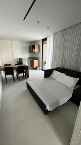 a bedroom with a large bed and a dining room at Porto Alto Resort - Porto de Galinhas in Porto De Galinhas