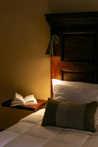 a bedroom with a bed with a book on a table at Habibi Room in Cedro