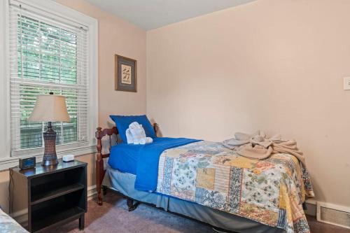 a bedroom with a bed and a lamp and a window at # Stay At Our Tasteful, Private, & Elegant Abode # in Devon
