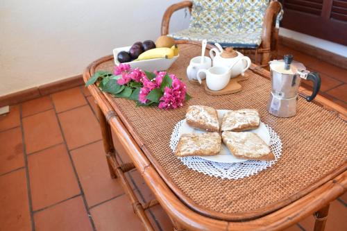 a table with a plate of bread and flowers on it at Sardegna23 - Appartamento Vacanze - in Orosei