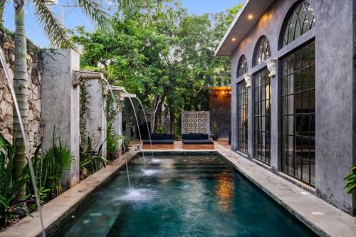 トゥルムにあるCasa Halo - Mansion, Nightclub, Pool, Sonos, Gated, Staffの裏庭に滝のある屋内プール