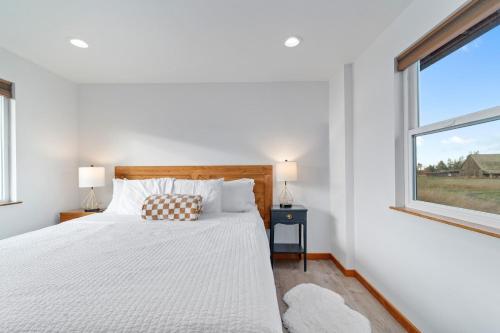 a white bedroom with a bed and a window at Frontier Farmhouse-sauna &ht in Port Angeles