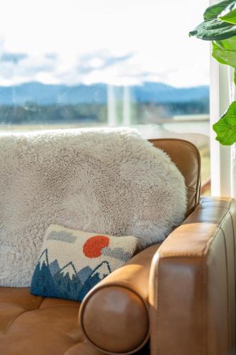 a couch with a blanket and a pillow on it at Frontier Farmhouse-sauna &ht in Port Angeles