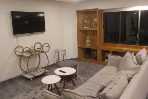 a living room with a couch and a tv at Zona Rosa Amberes 33 a 2 cuadras del CAS y del Ángel in Mexico City