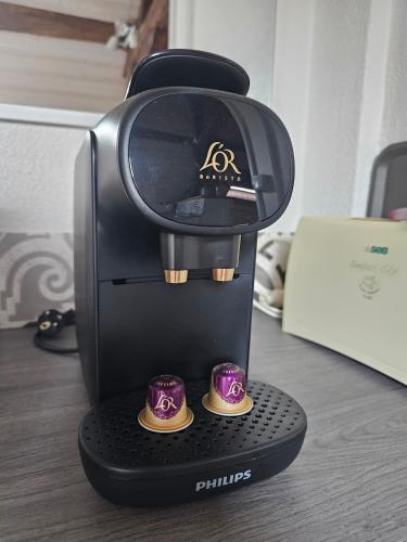 a coffee maker with purple cups on a table at AuxCerfs - Église Saint-Eusebe in Auxerre