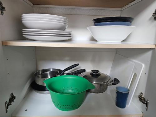 a kitchen shelf with bowls and plates and a pot at AuxCerfs - Église Saint-Eusebe in Auxerre