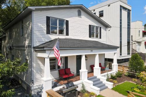 ein weißes Haus mit roten Stühlen und einer Flagge in der Unterkunft The Dobbs Atlanta Beltline - Luxury & Location, 1 Mile to Downtown Atlanta in Atlanta